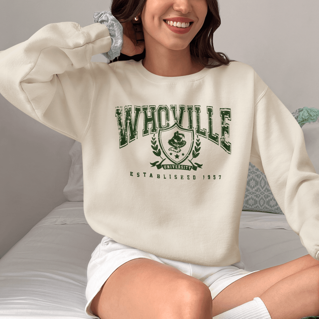 a beautiful woman wearing a cream sweatshirt with a college style design saying 'whosville' a subtle nod to the festive season.