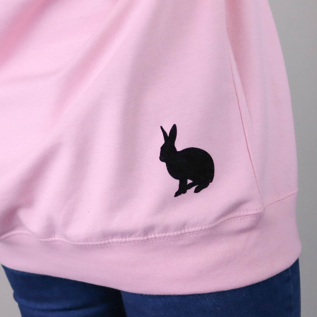 Woman wearing pink sweater with black wording "I'm late for a very important Date" and a silhouette of a small black rabbit by Original Monkey Gifts.
