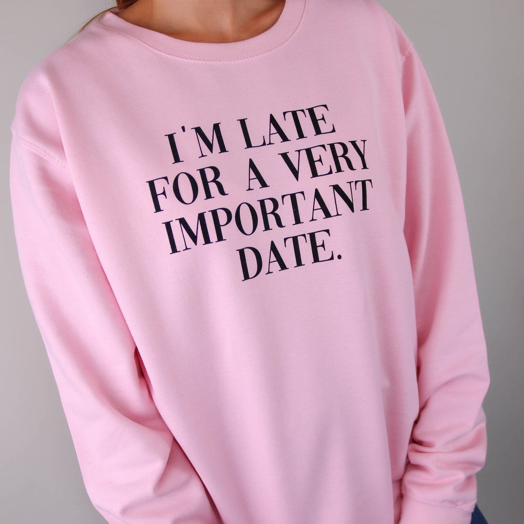 Woman wearing pink sweater with black wording "I'm late for a very important Date" by Original Monkey Gifts.