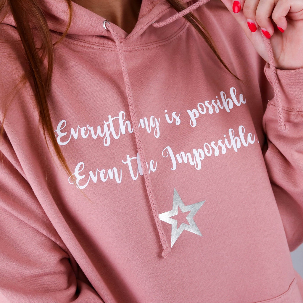 Women wearing Dusty Pink Hoodie with text reading "Everything is possible even the impossible" with white lettering. Made by Original Monkey