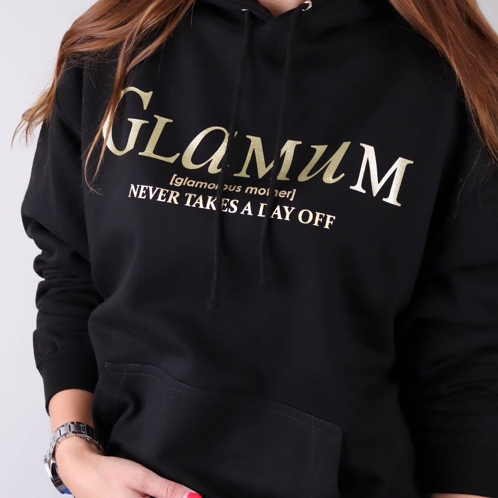 Woman wearing black Hoodie with gold text which says "Glamum Never takes a Day off" by Original Monkey Gifts