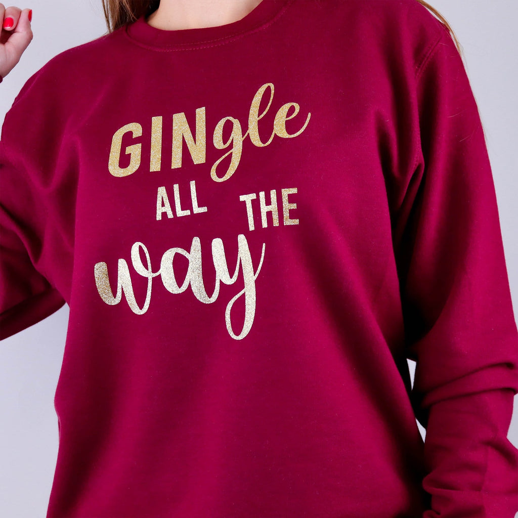 Woman wearing a burgundy Christmas jumper with text that reads 'GINgle all the way' in gold glitter by Original Monkey Designs.