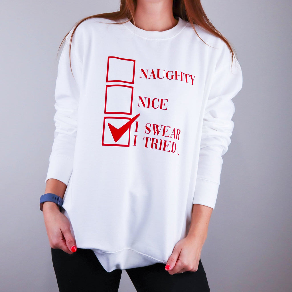 Woman wearing a white christmas jumper with text in red that reads 'Naughty, Nice, I swear I tried' by Original Monkey Gifts.