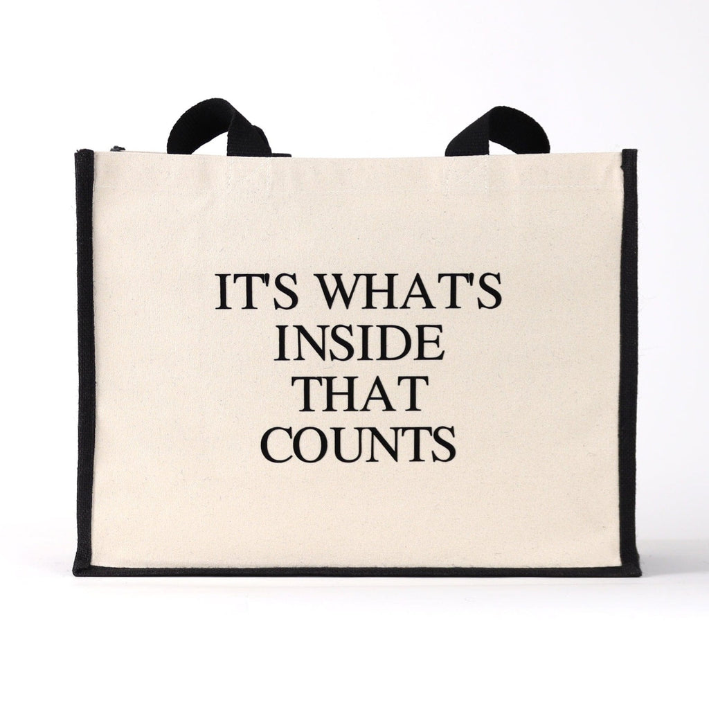 a black and natural tote bag with black wording saying "it's what's in side that counts" a great quality bag for everytday use, with a fashinable look to it