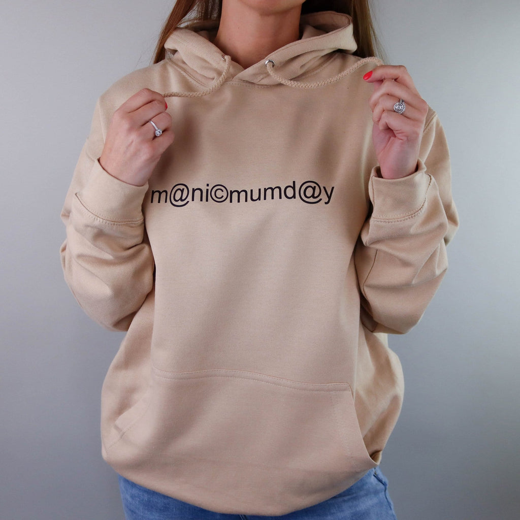 A woman wearing a sand coloured hoodie which says manic mumday creating a great gift idea for any mum