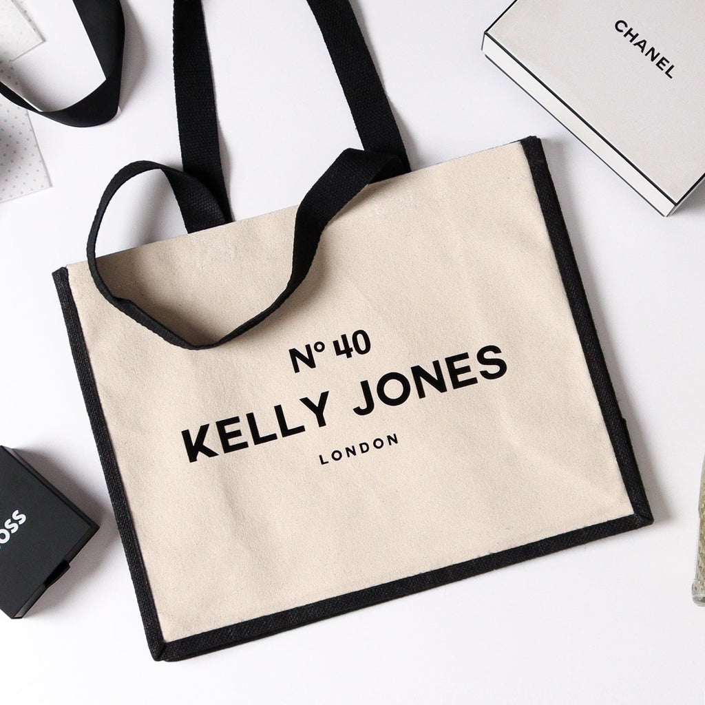 A balack and natural tote bag with personalisation on the front which is the number 40 the recipients name and then their city designed to imitate an expensive label on a perfume bottle, the wording is done in a really nice velvet feel material making this a truly great gift bag for life 