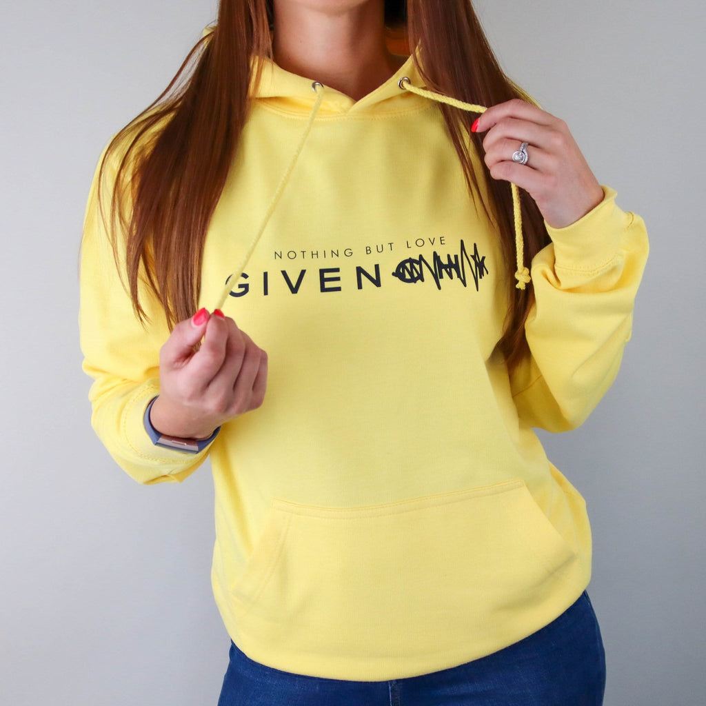 Woman wearing yellow hoodie with text saying nothing but love given paired with blue jeans. By Original Monkey Gifts
