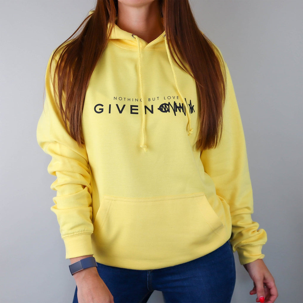Woman wearing yellow hoodie with text saying nothing but love given paired with blue jeans. By Original Monkey Gifts.